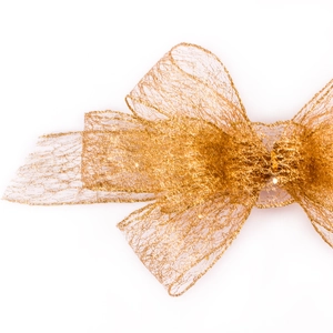 Macro shot of gold mesh bow with glittery lace texture and intricate hollow metallic weave