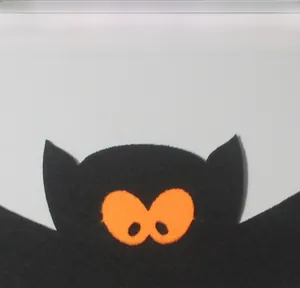 Vue macro de décoration de chauve-souris en feutre noir d'Halloween avec de grands yeux orange