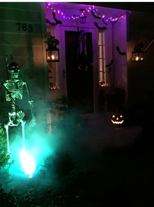 Detailed outdoor Halloween scene with glowing skeletons and purple bat light strings