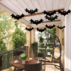 Set of black Halloween bat decorations with colored eyes hanging on a cozy terrace
