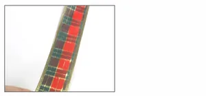 Detail of red and green plaid Christmas ribbon with gold wire edges for DIY crafts