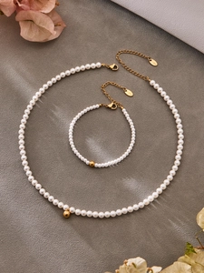 Detailed view of pearl jewelry set with golden beads and S.steel branded tags