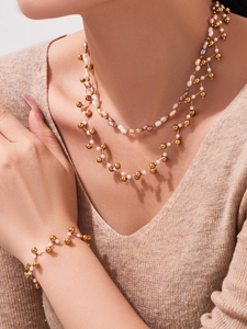 Detail of layered freshwater pearl necklace and bracelet set with golden beads