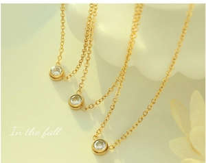 Close-up of three minimalist 18K gold plated zircon necklaces with bezel setting