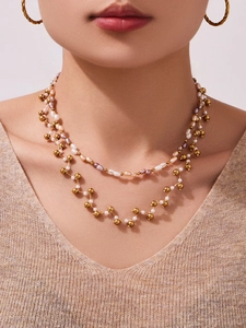 Close-up of layered necklace with natural lavender pearls and golden beads on model