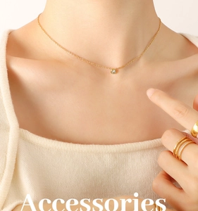 Close-up of 18K gold plated zircon pendant necklace and layered rings on a model