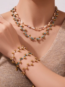Detail of layered beaded necklace and bracelet set with blue beads and pearls