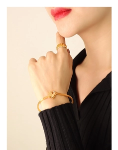 Detail of a gold butterfly cuff bracelet with frosted wings and sparkling zircon stone