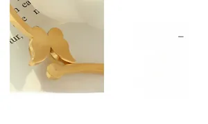 Detailed view of an open golden cuff bracelet featuring an elegant hollow butterfly design