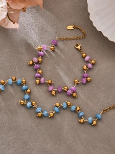 Detail of beaded jewelry set featuring purple and blue stones with stainless steel tag