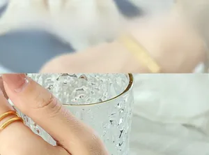 Detail of a minimalist gold-finished titanium steel double-layer ring on model finger