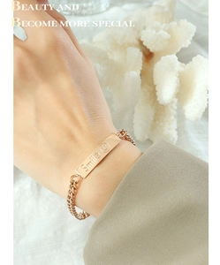 Detail of rose gold titanium steel link bracelet featuring an engraved Smile face charm