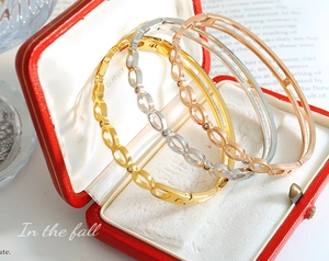 Détail de quatre bracelets minimalistes dorés et argentés dans un coffret cadeau en velours rouge