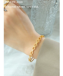 Détail du bracelet doré en forme de huit avec zircons sur le poignet d'un modèle