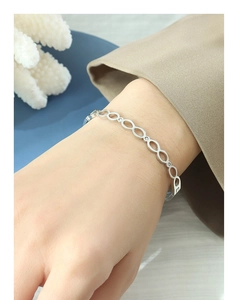 Détail d'un bracelet à maillons ovales argentés avec petits cristaux sur poignet