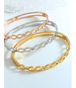 Détail de trois bracelets chiffre 8 porte-bonheur en or, argent et or rose avec zircon