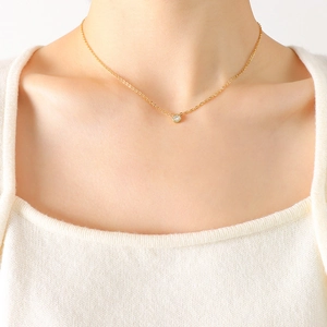 Minimalist 18K gold titanium steel necklace with a round bezel-set zircon pendant on a model