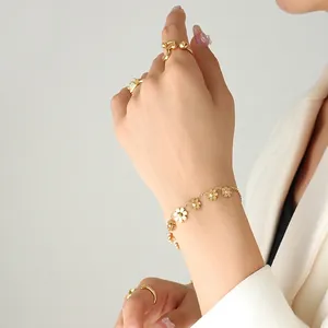 18K gold plated daisy flower bracelet and minimalist rings worn on a female wrist
