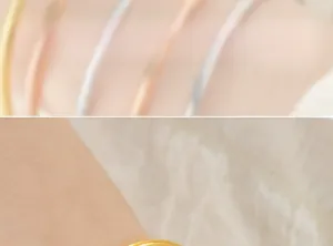 Close-up of minimalist gold plated titanium steel slim bangle showing polished finish