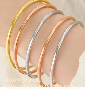 Detail shot of five minimalist polished titanium steel thin bangle bracelets on a model