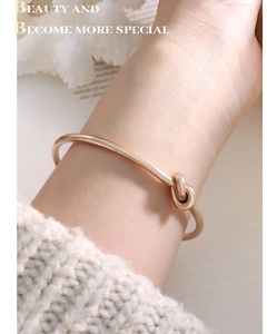 Dettaglio macro di un bracciale a nodo in oro rosa dal design minimalista elegante