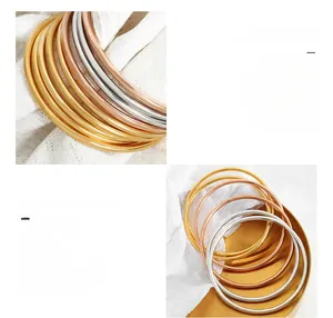 Macro detail of 18K gold plated titanium steel bangles in gold, silver and rose gold