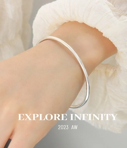 Minimalist polished silver bangle shown on wrist with clean fashion aesthetic