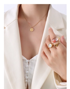 Detailed close-up of 18K gold-plated queen coin necklace and dry flower resin rings