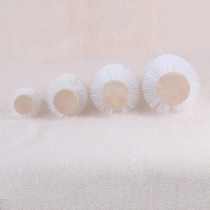 Set of four white nylon bristle cleaning brushes with natural round wooden base detail