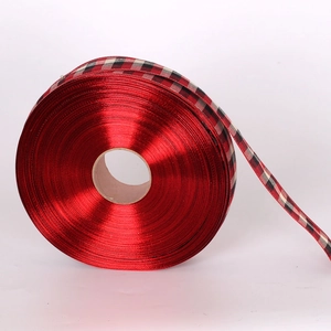 Détail d'un ruban de Noël rouge avec des bordures en tissu écossais rouge et noir classique