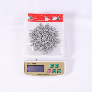 Glittery silver snowflake Christmas ornament on a digital scale showing weight details