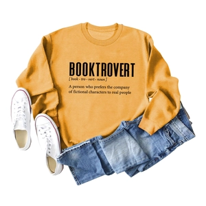 Flat lay of mustard yellow Booktrovert sweatshirt with jeans and white canvas shoes