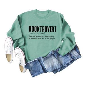 Detailed flat lay of sage green sweatshirt with Booktrovert print and casual outfit