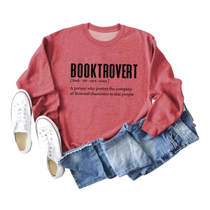 Flat lay of a brick red Booktrovert sweatshirt with white shoes and blue denim jeans