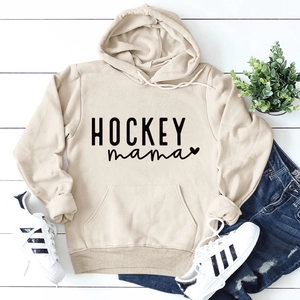 Mise à plat du sweat à capuche beige Hockey Mama avec jean bleu et baskets sur bois blanc
