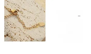 Detailed close-up of 18K gold plated lobster clasp and K18 hallmark on the extender chain