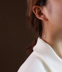 Close-up of elegant silver teardrop earrings worn by a model in high polish finish