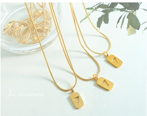 Makro-Detail der goldenen Schlangenkette aus Edelstahl mit hohlem Anhänger der Nummer 7