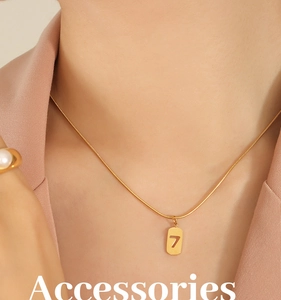 Detail einer goldenen Schlangenkette mit hohlem Anhänger der Nummer 7 am Modell