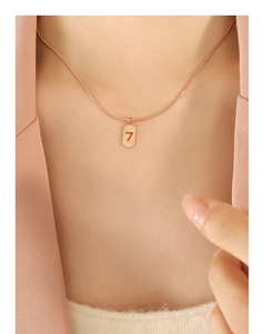 Detail der roségoldenen Schlangenkette mit Anhänger Nummer 7 auf der Haut getragen