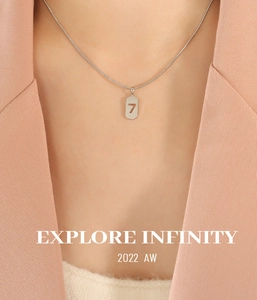 Details einer silbernen Schlangenkette mit einem Anhänger mit der Glückszahl 7