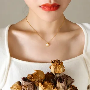 Elegante 18K vergulde titanium ketting met schelpparel gedragen door een vrouwelijk model