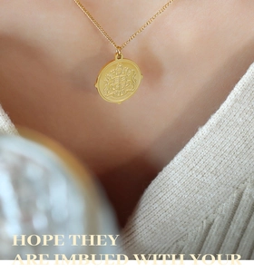 Close-up of golden round pendant necklace with royal crest on a fine cross chain