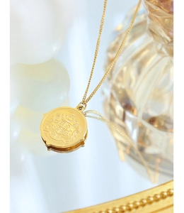 Macro detail of 18k gold plated necklace featuring a vintage crest coin pendant design