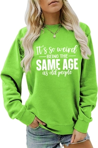 Detail of neon green sweatshirt with It's so weird being the same age slogan print