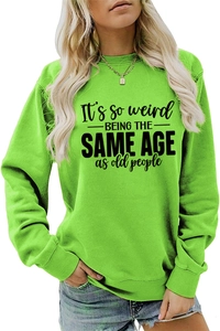Close-up of It's So Weird slogan print on neon green crewneck long sleeve sweatshirt