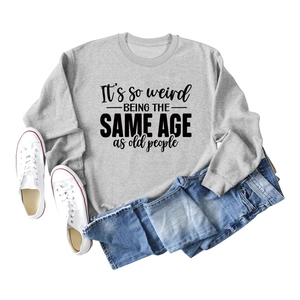 Flat lay of gray crewneck sweatshirt with black artsy text print and blue jeans
