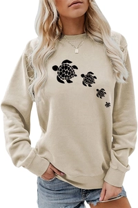 Detailed close-up of four black turtle silhouettes on a beige cotton crewneck sweatshirt