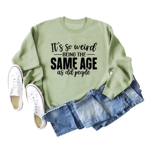 Flat lay of casual crewneck sweatshirt with slogan print, jeans and white canvas shoes