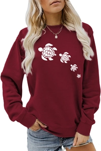 Detail of burgundy crewneck sweatshirt featuring white sea turtle prints on soft cotton fabric